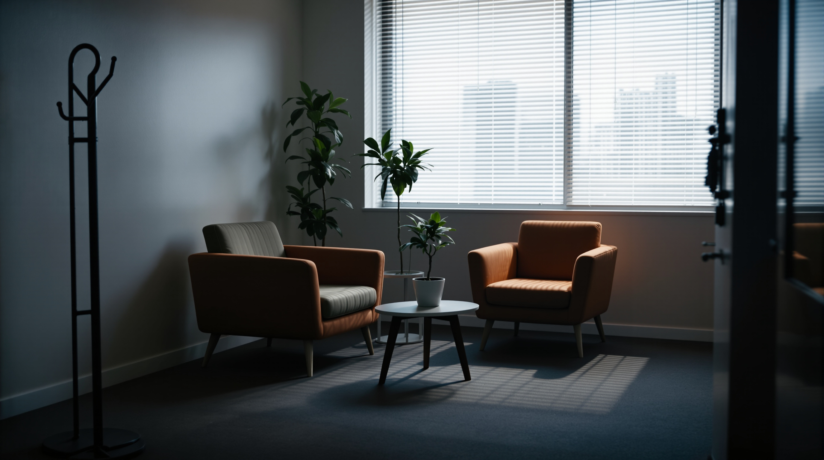 A quiet accounting office reception desk after hours, one desk lamp lit, a telephone and paperwork neatly arranged